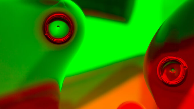 två kameralinser i rött och grönt ljus.